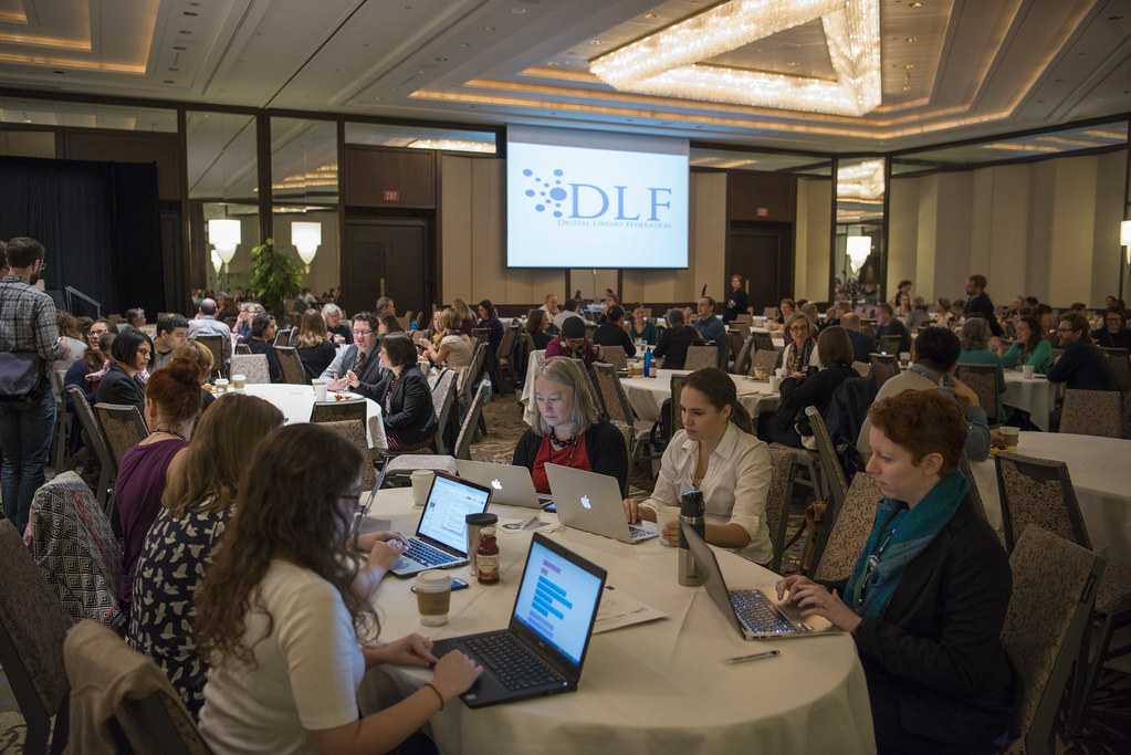 Attendees at seated at table looking at computers