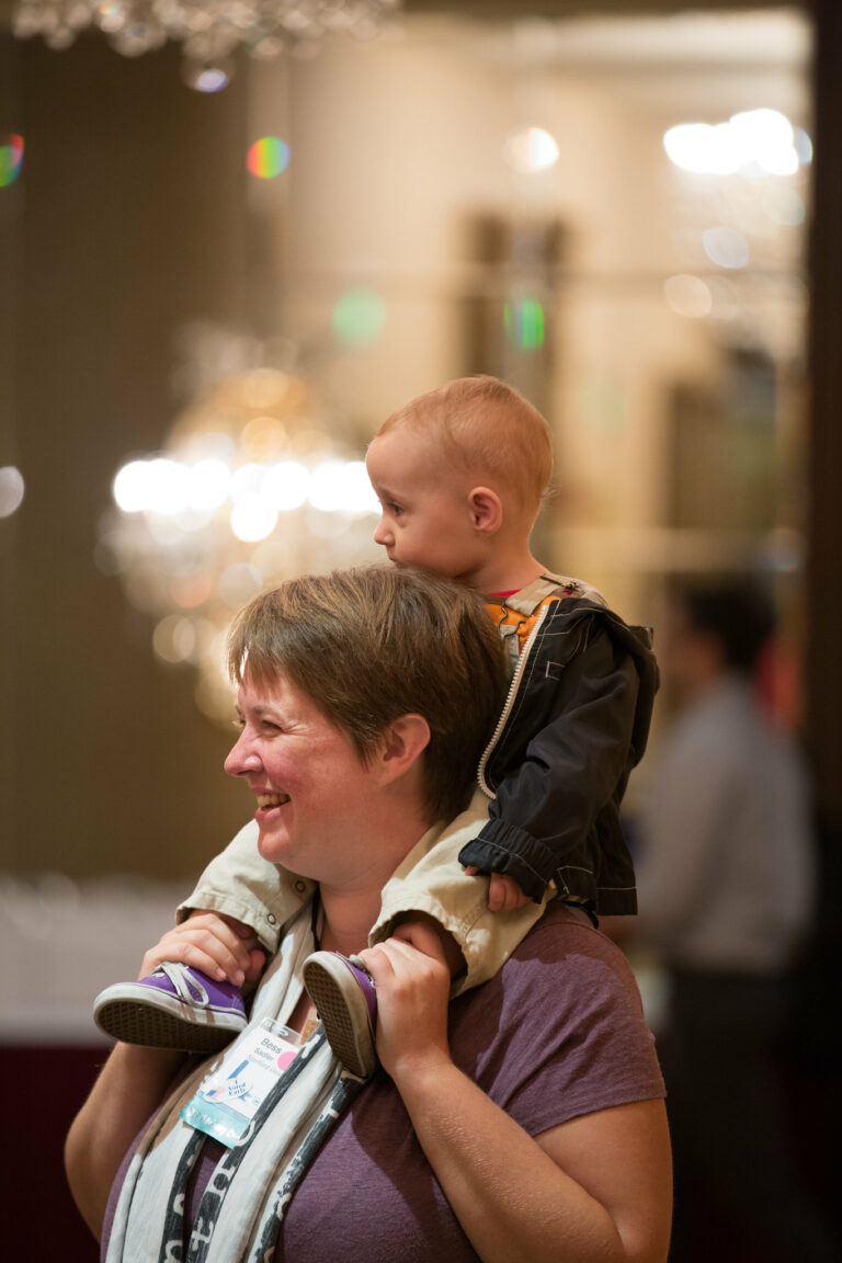 2016 DLF Forum attendee with a young boy sitting on her shoulders