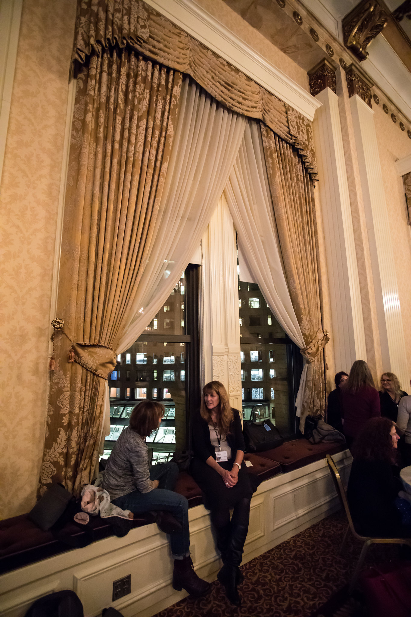 attendees sitting by a window chatting during the 2016 DLF Forum reception